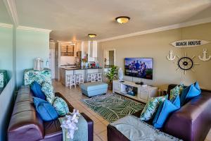 ein Wohnzimmer mit 2 Sofas und einem TV in der Unterkunft Sands Beach Breaks Luxury Beach Front Ballito in Ballito