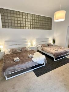 two beds in a white room with two bedsvisor at Apartment Lea - Old Town in Bratislava