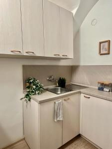 uma cozinha com armários brancos e um lavatório em Apartment Lea - Old Town em Bratislava