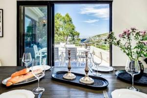 a dining room table with wine glasses and vegetables on it at Table Mountain Views in Cape Town