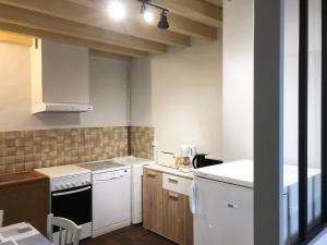 a small kitchen with white appliances and wooden cabinets at La Renardie in La Ferté-Imbault