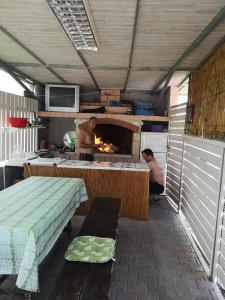 Dois homens numa cozinha com um forno de pizza. em Apartmani Betina - Petra Preradovića 2K em Betina