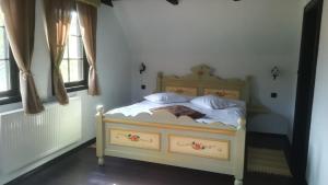 a bedroom with a bed with white sheets at Casuta Bunicii, Bran in Bran