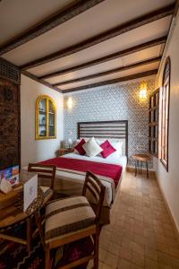 una camera con letto, tavolo e sedie di Riad Cologne & Spa a Marrakech
