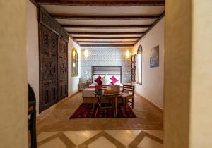 un soggiorno con tavolo e divano di Riad Cologne & Spa a Marrakech