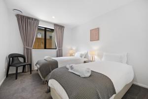 Habitación de hotel con 2 camas y ventana en Elite Holiday Homes - Remarkable Retreat, en Frankton