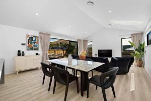 comedor y sala de estar con mesa y sillas en Elite Holiday Homes - Remarkable Retreat, en Frankton