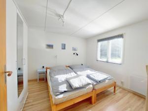 ein weißes Schlafzimmer mit einem Bett und einem Fenster in der Unterkunft Woody in Brösarp