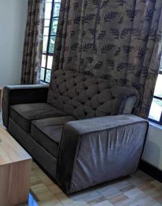 un sofá de cuero en una sala de estar con ventana en Mwacha_Farm_house, en Moshi