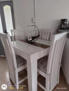 uma mesa de jantar branca com 2 cadeiras em RL'Brothers em Antananarivo