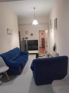 a living room with a blue couch and a tv at Apartment MCS in Igoumenitsa