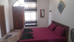 Cama morada en habitación con ventana en Suriya Villa en Kandy