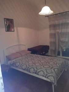 a bedroom with a bed and a lamp and a window at Apartment MCS in Igoumenitsa