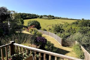 a garden with a wooden fence and some flowers at The Hutch Devon in Longdown