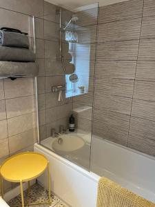 a bathroom with a tub and a table and a yellow stool at The Hutch Devon in Longdown