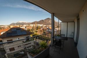 een balkon met een tafel en uitzicht op de stad bij La Ruche des carrés - T3 vue panoramique in Annecy