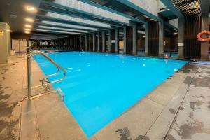 a large blue swimming pool in a building at Modern Wellness Studio in Budapest