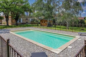 a swimming pool in a yard with a fence at La Maison de Clément in Lisle-sur-Tarn