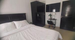 a bedroom with a white bed and black cabinets at Chandra's guest house in Pesanggaran