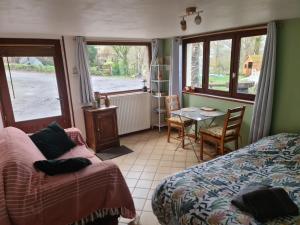 1 dormitorio con cama, mesa y ventana en Chambre à la ferme, les vergers du Muscardin en Bréel