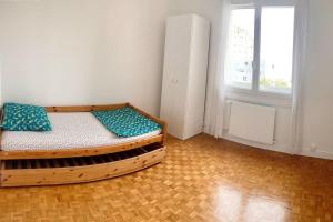 um quarto com uma cama de madeira e uma janela em Appartement bien situé em Noisy-le-Grand