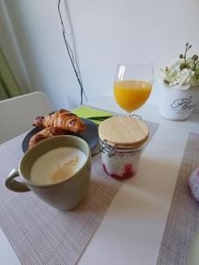 a table with a cup of coffee and a glass of orange juice at Harmónia Apartman Balatonföldvár in Balatonföldvár