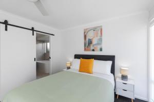 a white bedroom with a white bed and a yellow pillow at Heinlen on North Terrace in Mount Gambier