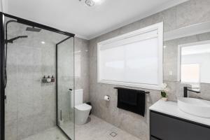 a bathroom with a shower and a toilet and a sink at Heinlen on North Terrace in Mount Gambier