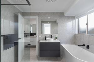 a bathroom with a tub and a sink and a bath tub at Heinlen on North Terrace in Mount Gambier
