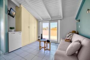 a living room with a couch and a kitchen at Platy Beach Hotel in Platy