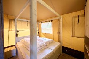 a bed in a room with a pole at Glamping Ackersate in Voorthuizen
