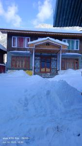 a house with a pile of snow in front of it at Royal galaxy in Pahalgām