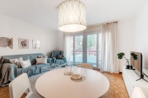 a white living room with a table and a couch at Pink Flat by Quokka 360 - close to the Italian border in Chiasso