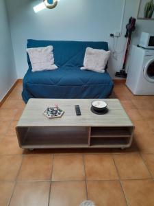 ein Wohnzimmer mit einem blauen Sofa und einem Couchtisch in der Unterkunft appartement city 2 d'Amiens in Amiens