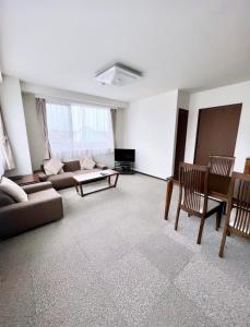 een woonkamer met een bank en een tafel bij ホテル辰巳俱楽部 