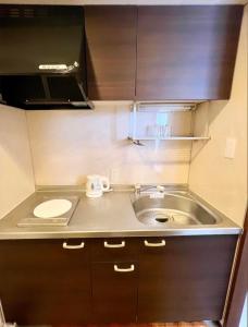 een kleine keuken met een wastafel en een toilet bij ホテル辰巳俱楽部 