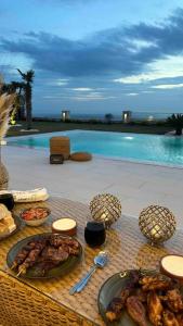 uma mesa com comida ao lado de uma piscina em Villa safkan em Silivri