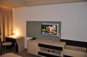 ein Hotelzimmer mit einem TV an der Wand in der Unterkunft Hotel Nova in Târgovişte