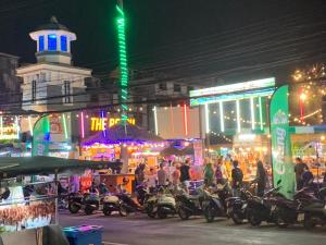 un groupe de motocycles garés dans une rue la nuit dans l'établissement Fullmoon Jomtien Guest house, à Jomtien Beach