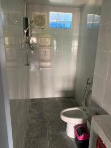 a bathroom with a white toilet and a window at Fullmoon Jomtien Guest house in Jomtien Beach