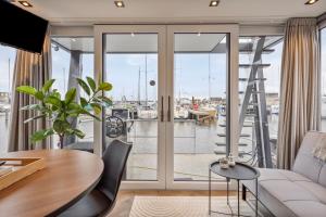 a living room with a view of a harbor at Luxurious waterloft near beach and centre in Zeewolde