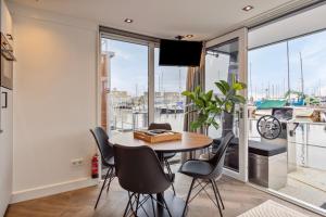 een eetkamer met een tafel en stoelen en een groot raam bij Luxurious waterloft near beach and centre in Zeewolde