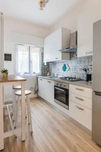una cocina con armarios blancos y una mesa. en monji apartment en Faenza