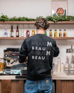 パリにあるBeau M Parisの台所のコンロ前に立つ男