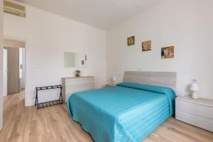 um quarto com uma cama azul e paredes brancas em monji apartment em Faenza