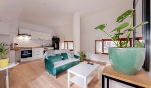 a living room with a couch and a table with a potted plant at Huge House 210sqm 19 people Private Outdoor 2 Parking Top Location in Saint-Ouen +14 photos