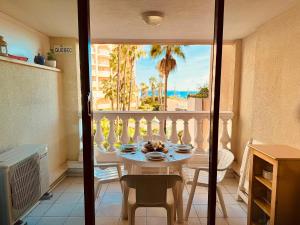 a room with a table with a view of the ocean at LE PALM AZUR - vue mer sur les iles de Lérins in Cannes