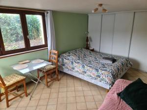 1 dormitorio con cama, mesa y ventana en Chambre à la ferme, les vergers du Muscardin, en Bréel