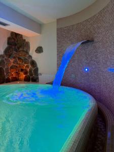 a swimming pool with a waterfall in a room at Residence Villa Flora in Canazei