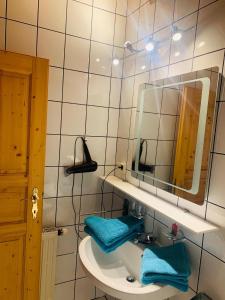a bathroom with a sink with a mirror and blue towels at Ferienhaus Sükar in Bad Kleinkirchheim
